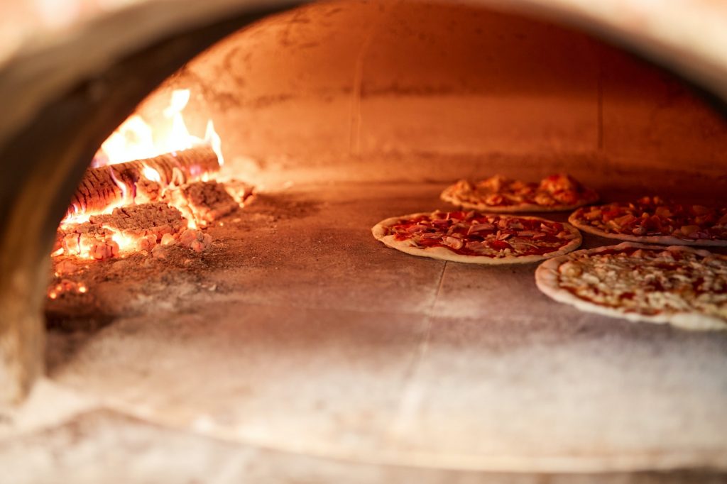 pizza baking in oven at pizzeria